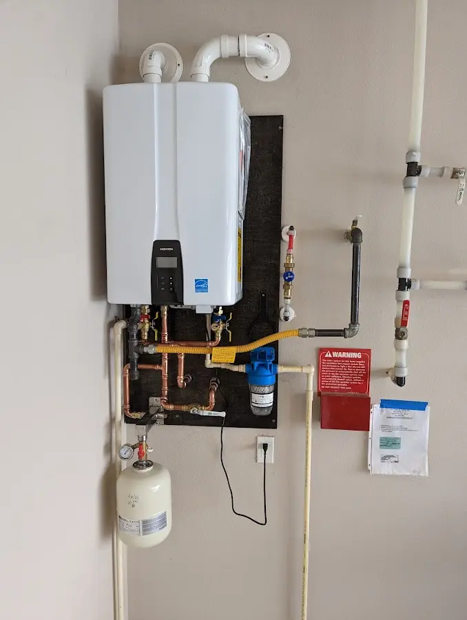 Professional plumber installing copper piping in a Masonville home